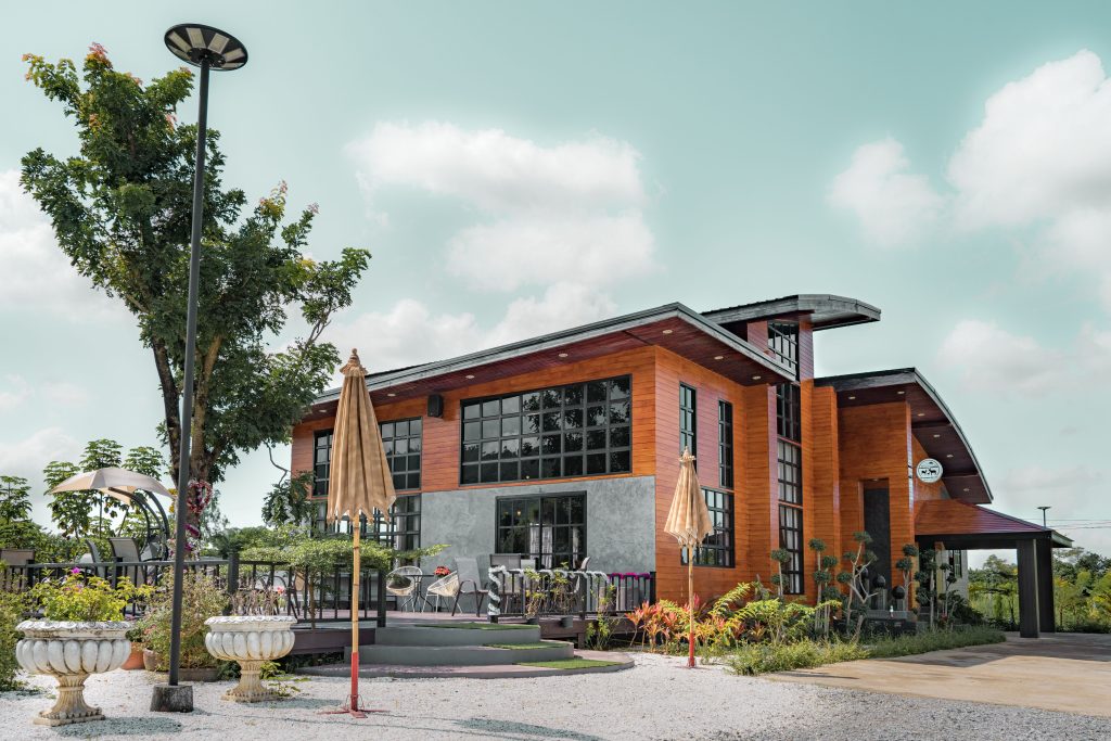 Contemporary wooden lodge surrounded by nature in Phitsanulok, Thailand, featuring elegant outdoor seating.